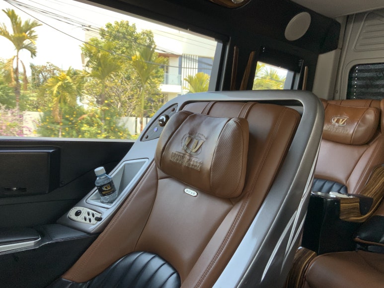 Interior of a Vexere limousine van featuring wide leather seats and a private, spacious layout.