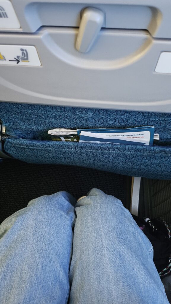 Vietnam Airlines economy seat legroom view showing knee space and in-seat magazine pocket from a passenger's perspective.
