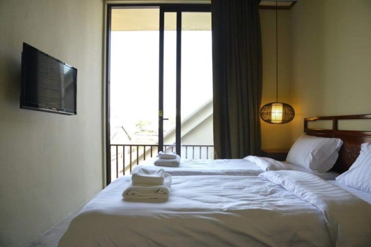 Minimalist twin bed room with balcony and TV at Villa Prasumen Bangkok
